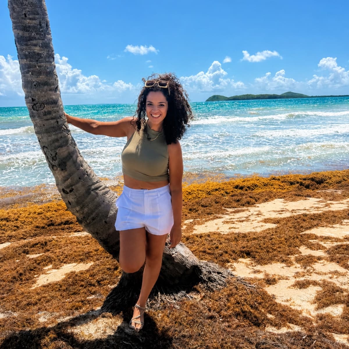 Dr. Espinet on a beach by a palm tree