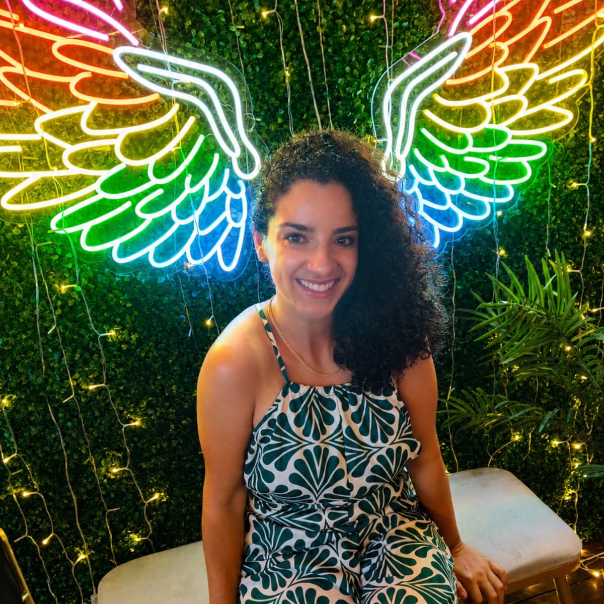 Dr. Espinet in front of neon rainbow wings